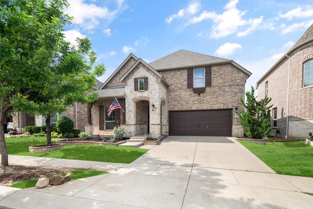 view of front of home with a garage, a front yard, driveway, and brick siding
