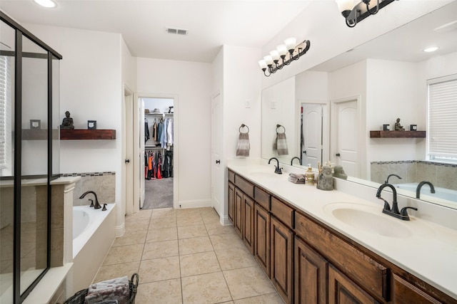 bathroom with visible vents, a garden tub, tile patterned flooring, double vanity, and a sink