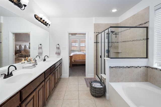 bathroom with a stall shower, a bath, tile patterned floors, a sink, and ensuite bath