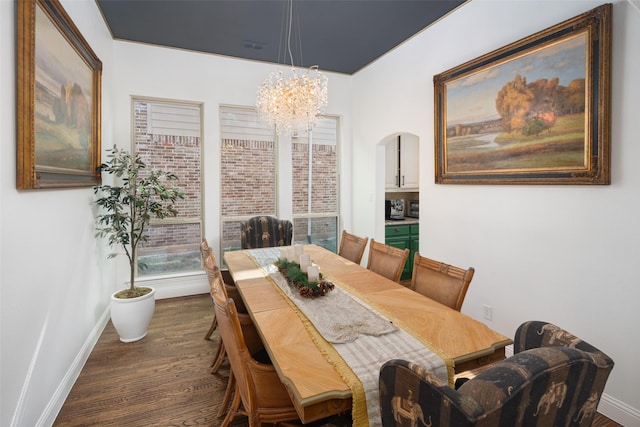 dining space featuring arched walkways, baseboards, and dark wood finished floors
