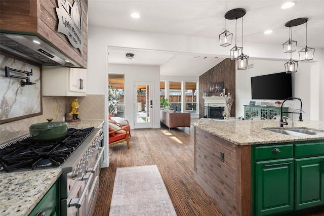 kitchen featuring a sink, backsplash, open floor plan, and range with two ovens
