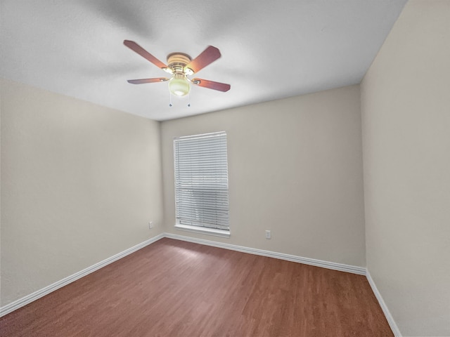 empty room with baseboards, a ceiling fan, and wood finished floors