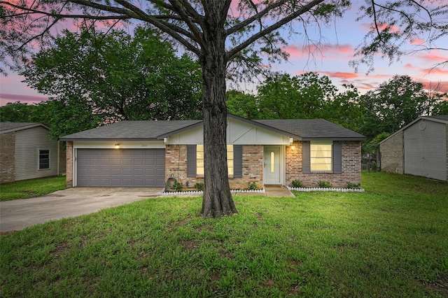 ranch-style home featuring a yard, brick siding, driveway, and a garage