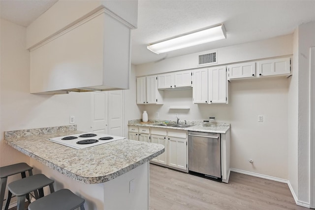 kitchen featuring a breakfast bar area, stainless steel dishwasher, light countertops, cooktop, and a sink