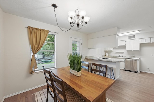dining room with visible vents, baseboards, light wood finished floors, and a notable chandelier