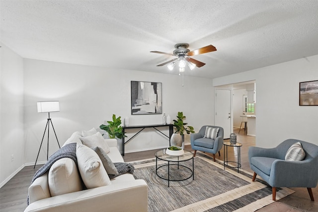 3610 Biscay Dr, Arlington, TX 76016 - living area with a ceiling fan, wood finished floors, a textured ceiling, and baseboards
