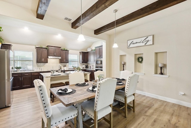 dining room featuring visible vents, light wood-style flooring, baseboards, and vaulted ceiling with beams