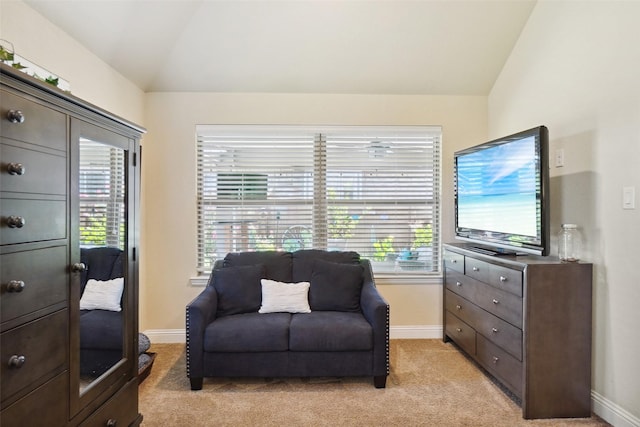 sitting room with baseboards, light colored carpet, and lofted ceiling
