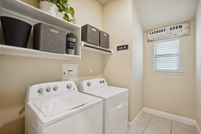 laundry area featuring light tile patterned flooring, laundry area, washing machine and dryer, and baseboards