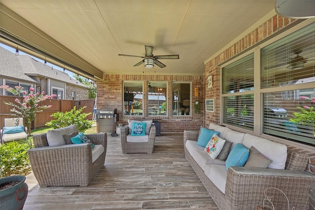 wooden terrace with grilling area, ceiling fan, fence, and an outdoor hangout area