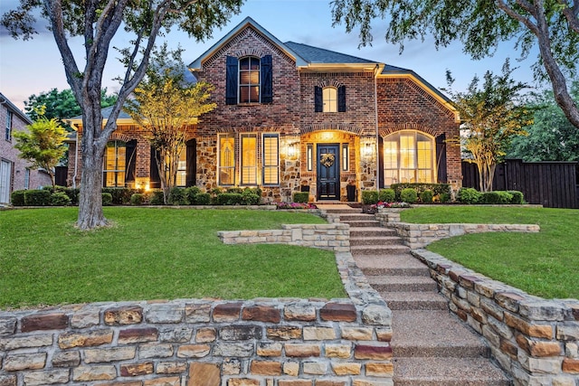 view of front of property featuring fence, a front lawn, and brick siding
