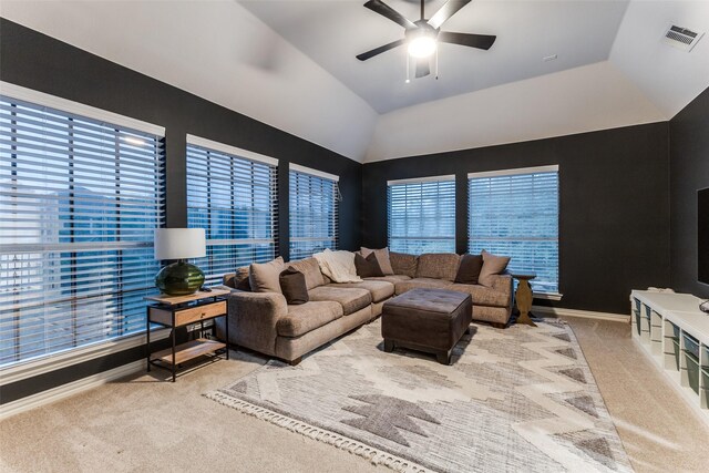 carpeted living room with ceiling fan, visible vents, a wealth of natural light, and vaulted ceiling