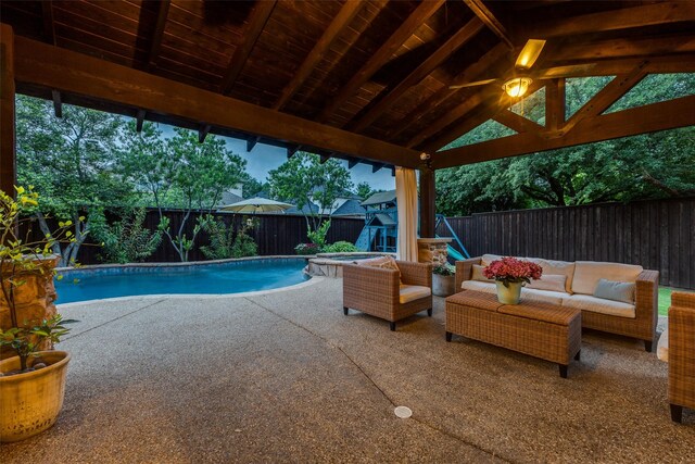 view of pool with fence, a pool with connected hot tub, a patio area, and a grill