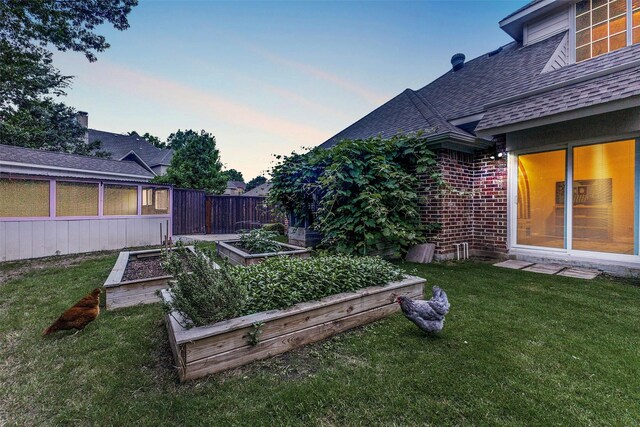 view of yard with a sunroom and a garden