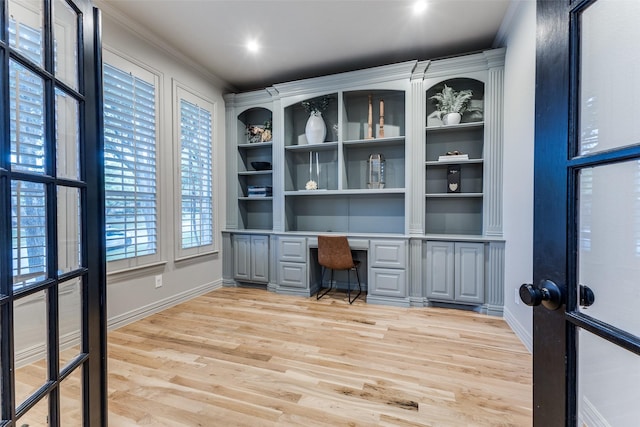 foyer entrance featuring arched walkways, baseboards, light wood-style flooring, and stairway