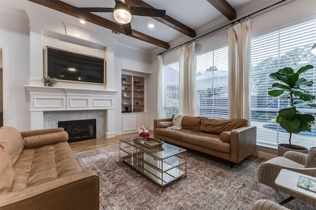 living area featuring arched walkways, beamed ceiling, and visible vents