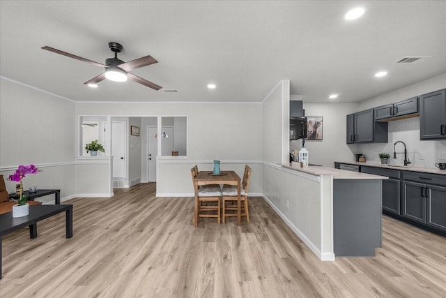 1013 Springdale Rd, Bedford, TX 76021 - kitchen with black microwave, light wood-type flooring, a sink, light countertops, and recessed lighting