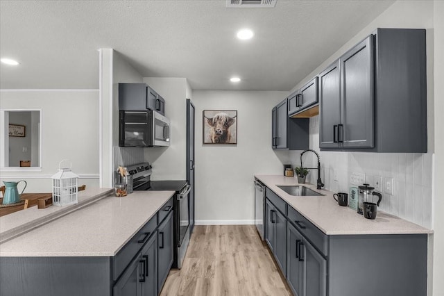 1013 Springdale Rd, Bedford, TX 76021 - kitchen with a sink, light countertops, stainless steel appliances, and light wood-type flooring