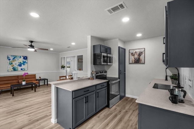 1013 Springdale Rd, Bedford, TX 76021 - kitchen featuring appliances with stainless steel finishes, a sink, light countertops, a textured ceiling, and visible vents
