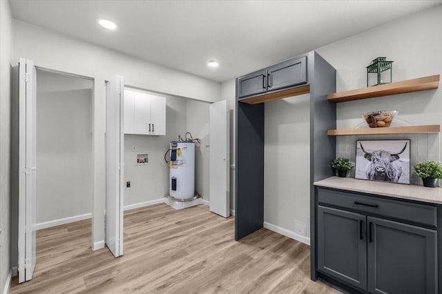 1013 Springdale Rd, Bedford, TX 76021 - washroom featuring cabinet space, light wood finished floors, water heater, and hookup for a washing machine