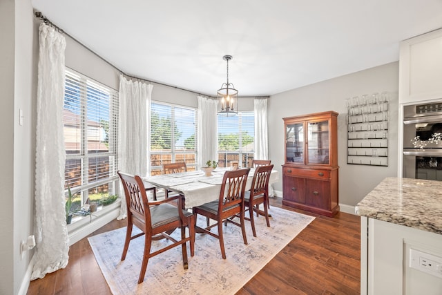 dining area with baseboards, dark wood finished floors, and a chandelier