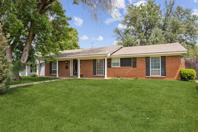 ranch-style house featuring brick siding, fence, and a front lawn