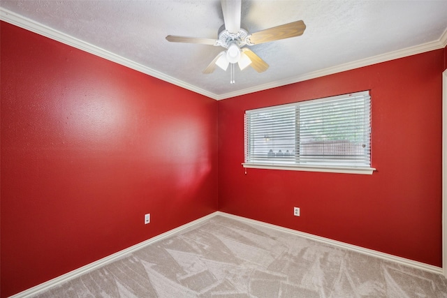 spare room with crown molding, a ceiling fan, baseboards, and carpet
