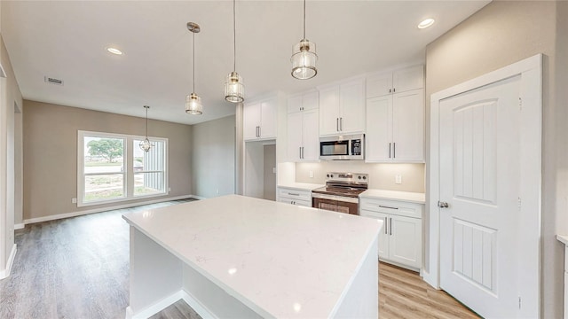 kitchen with appliances with stainless steel finishes, light wood-type flooring, white cabinetry, and visible vents