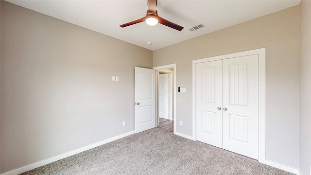 unfurnished bedroom with a closet, visible vents, baseboards, ceiling fan, and carpet