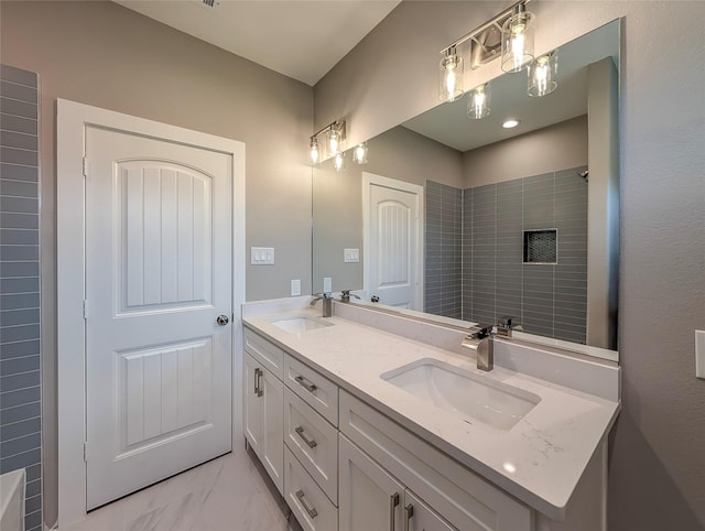 bathroom featuring double vanity, a sink, marble finish floor, and a shower