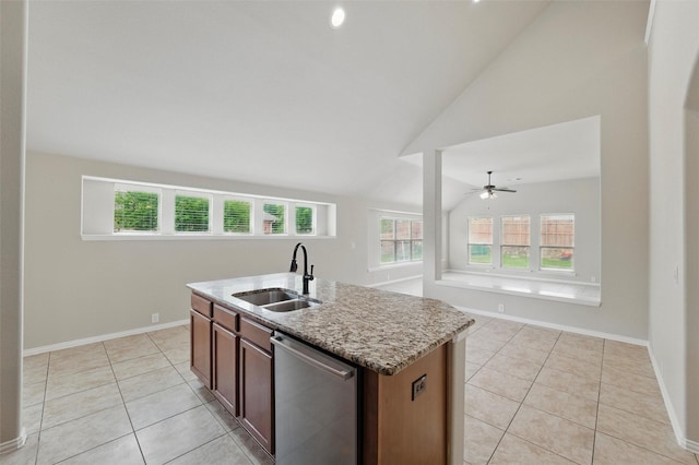 kitchen with light tile patterned flooring, light stone countertops, vaulted ceiling, and a sink