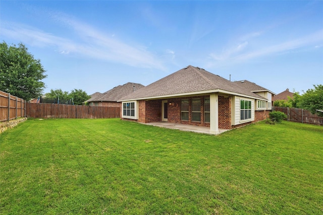 back of house featuring a patio, a fenced backyard, and a lawn