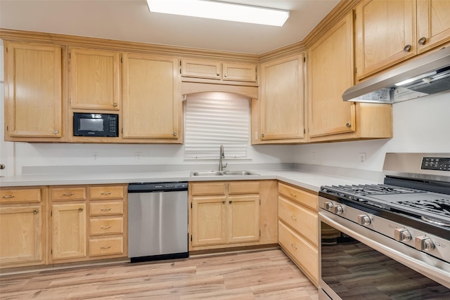 kitchen with a sink, light wood-style floors, light brown cabinets, stainless steel appliances, and under cabinet range hood