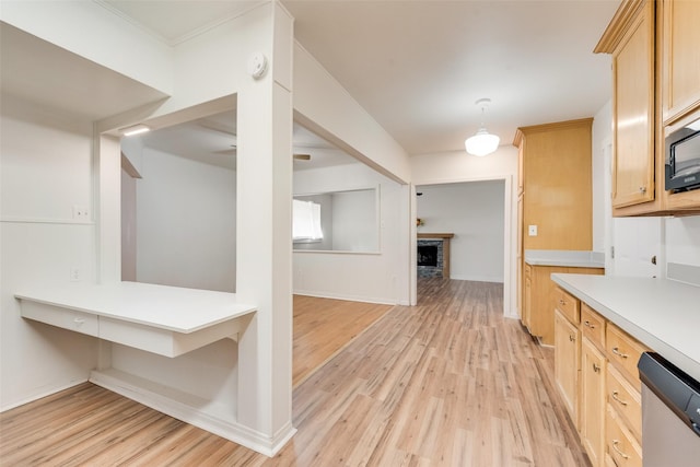 kitchen with stainless steel dishwasher, light countertops, light wood finished floors, and light brown cabinetry