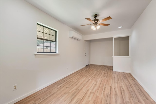 unfurnished bedroom with an AC wall unit, baseboards, ceiling fan, and wood finished floors