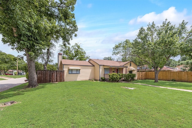 ranch-style house with a front lawn, fence, and a chimney