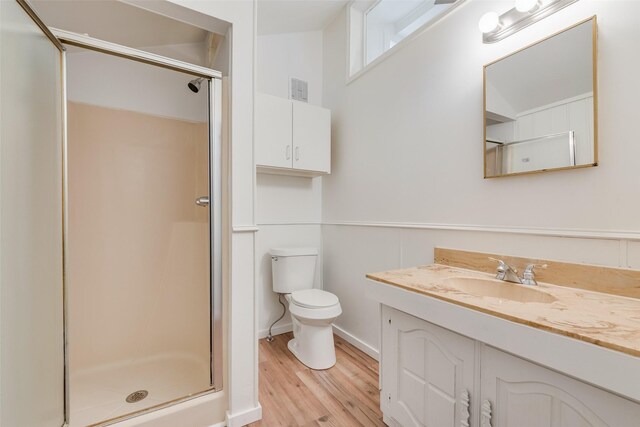 full bathroom featuring visible vents, vanity, wood finished floors, toilet, and a stall shower