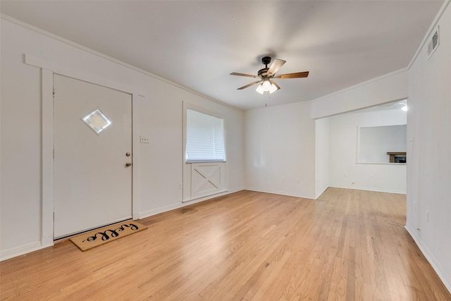 foyer entrance with crown molding, light wood-style floors, a ceiling fan, baseboards, and visible vents