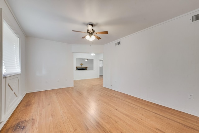 unfurnished room featuring a ceiling fan, baseboards, visible vents, and light wood-style flooring