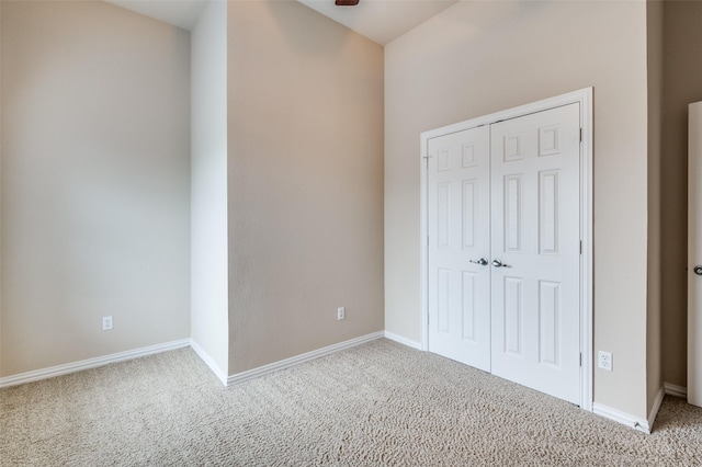 unfurnished bedroom with carpet floors, baseboards, and a closet