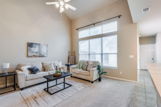 living area with high vaulted ceiling, a wealth of natural light, a ceiling fan, and visible vents