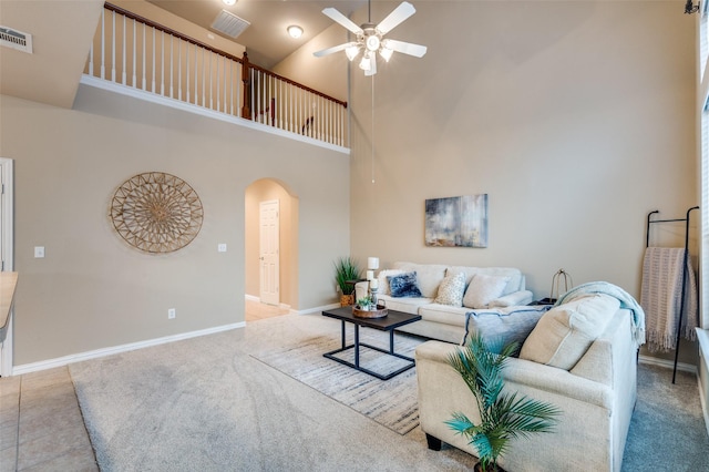living area featuring ceiling fan, arched walkways, high vaulted ceiling, carpet, and visible vents