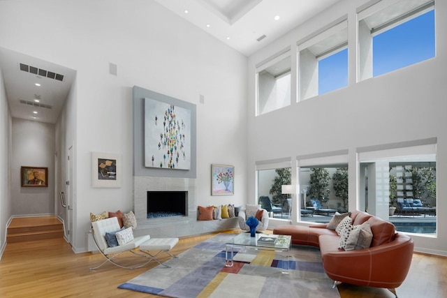 11715 Parwen Dr, Dallas, TX 75230 - living room featuring visible vents, a towering ceiling, wood finished floors, and a fireplace