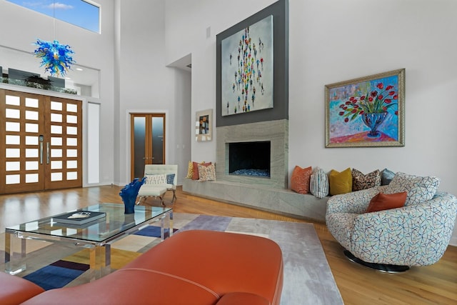11715 Parwen Dr, Dallas, TX 75230 - living area with french doors, a high end fireplace, a towering ceiling, and wood finished floors
