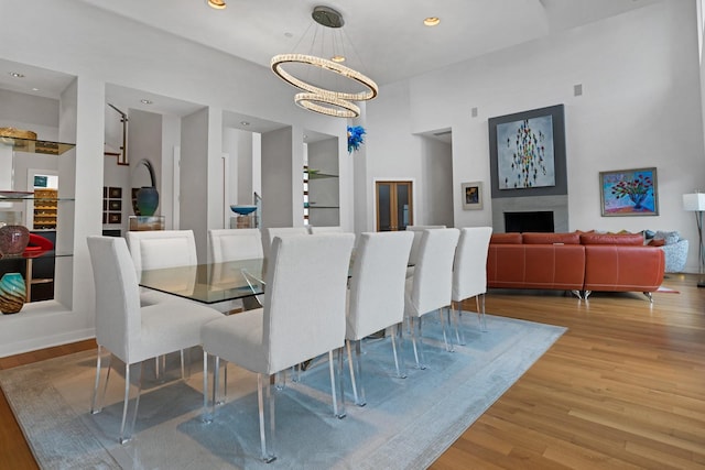 11715 Parwen Dr, Dallas, TX 75230 - dining space with a fireplace, built in shelves, wood finished floors, an inviting chandelier, and recessed lighting