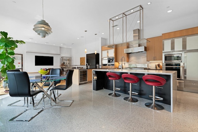 11715 Parwen Dr, Dallas, TX 75230 - kitchen featuring stainless steel appliances, an island with sink, modern cabinets, and light speckled floor