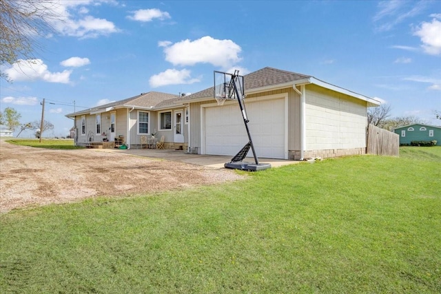 rear view of property with a lawn, an attached garage, driveway, and roof with shingles
