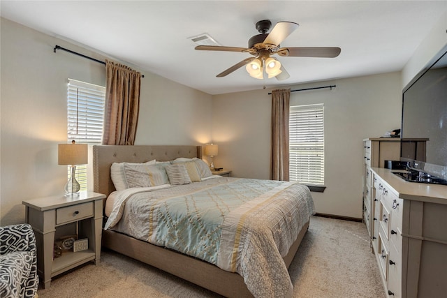 bedroom with light colored carpet, baseboards, ceiling fan, and visible vents