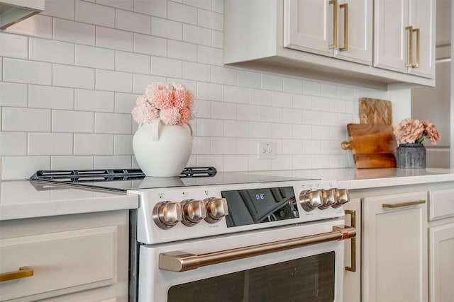 room details featuring light countertops, decorative backsplash, and electric range oven