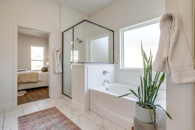 bathroom featuring ensuite bathroom, a shower stall, marble finish floor, and a wealth of natural light